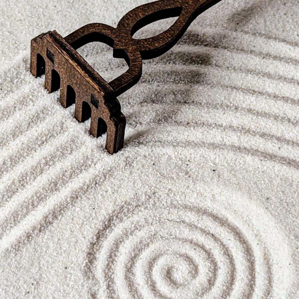 Harke, die Muster in den Sand malt.